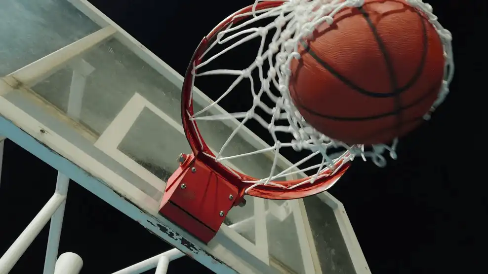 Kosárlabda éppen áthalad a palánk gyűrűjén.