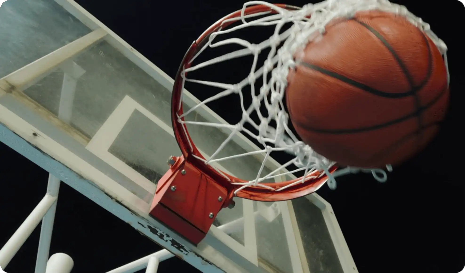 Kosárlabda éppen áthalad a palánk gyűrűjén.