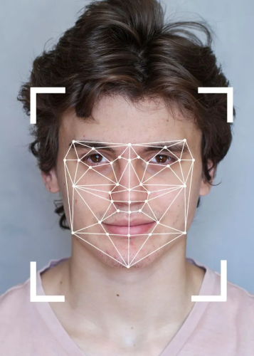 Egy fiatal férfi arca, amelyre digitális arcfelismerő háló és fókuszkeret vetül. 