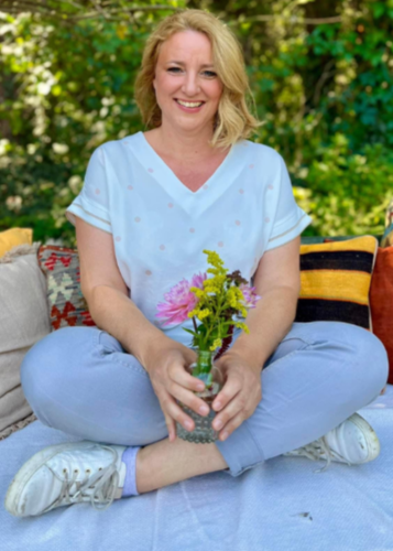 Egy férfi ül egy asztalnál, elegáns, mintás ingben, kezével magyarázó mozdulatot tesz, háttérben egy üres flipchart tábla. Fókuszált tekintettel beszél. Prezentáció, megbeszélés, üzleti találkozó, magyarázat, szakértő, oktatás, kommunikáció, irodai környe